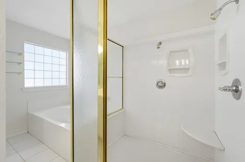 a white bath tub sitting next to a shower