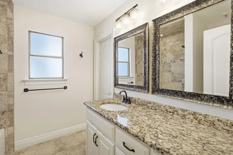 a bathroom with a granite countertop sink a toilet and bathtub