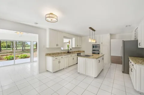 a kitchen with granite countertop a sink and a stove top oven