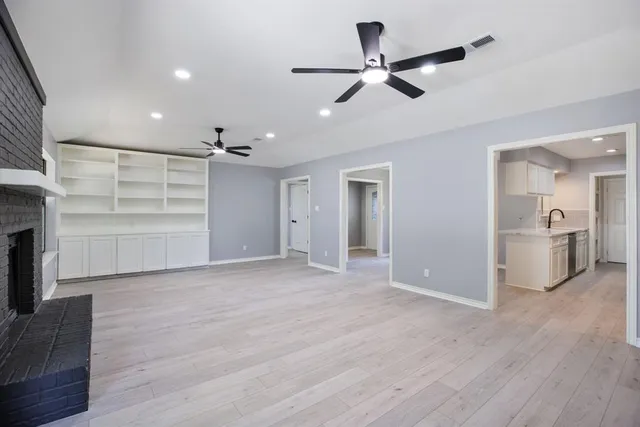 a view of a livingroom with a ceiling fan wooden floor and a ceiling fan