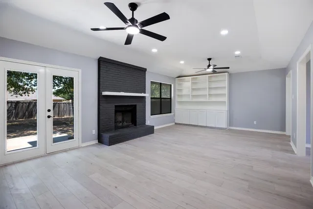 a view of an empty room with a fireplace and a window