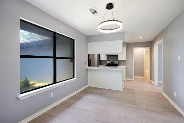 a view of kitchen with stainless steel appliances granite countertop a refrigerator a oven a sink and a window