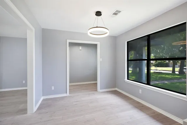 a view of a room with a large window and wooden floor