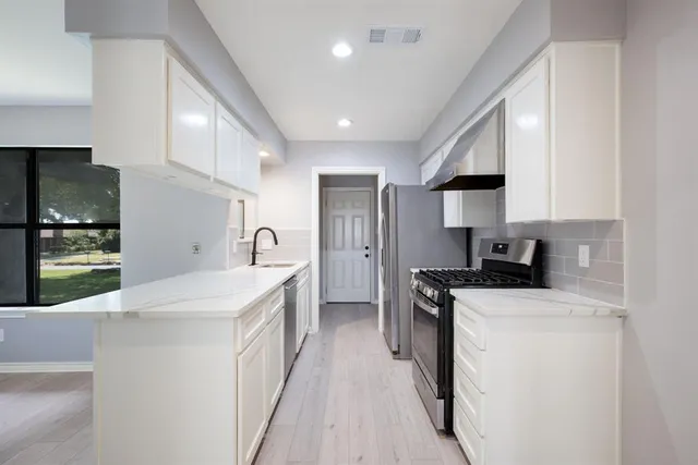 a kitchen with a sink a stove and cabinets