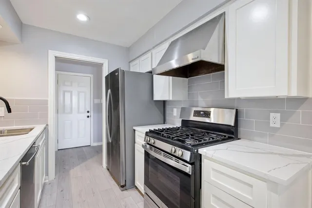 a kitchen with stainless steel appliances a stove a sink and a refrigerator