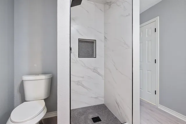 a white toilet sitting next to a bathroom sink