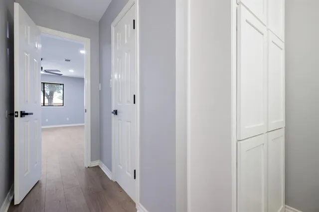 a view of a hallway with wooden floor