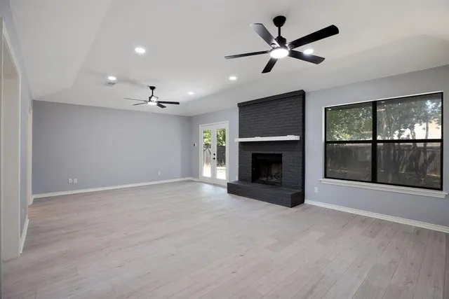 a view of empty room with a fireplace and fan