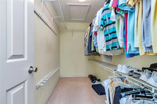 a view of walk in closet with clothes and shoes