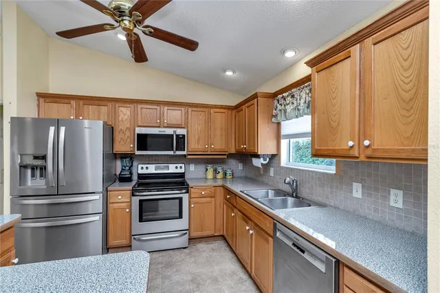 a kitchen with stainless steel appliances a refrigerator sink and microwave