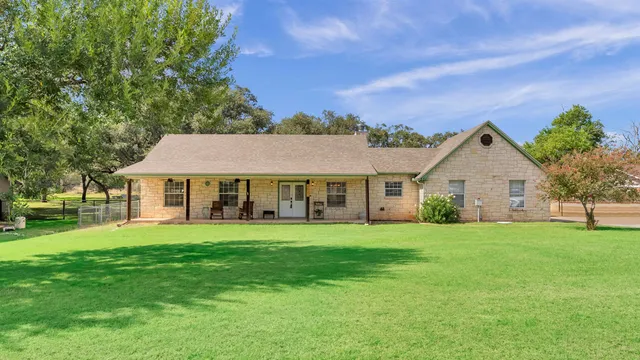 a front view of a house with a yard and trees