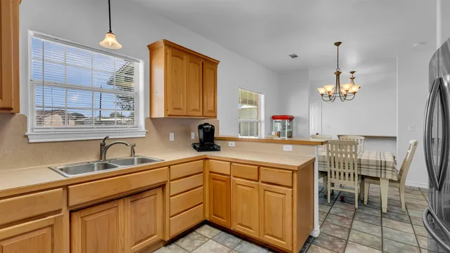 a kitchen with cabinets a sink dining table and chairs
