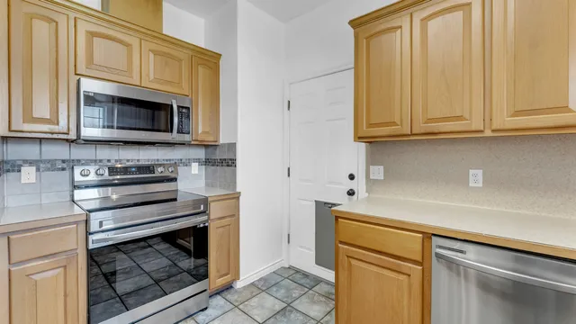 a kitchen with granite countertop white cabinets and stainless steel appliances