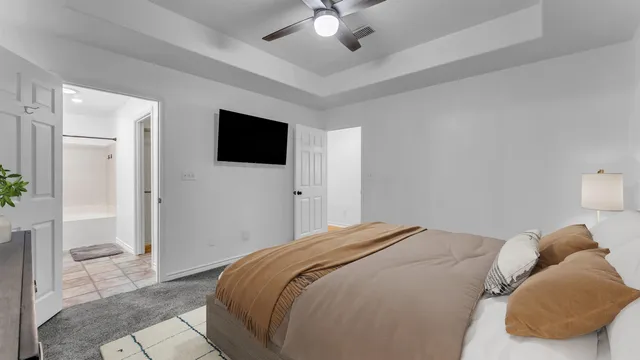 a bedroom with a large bed and a flat screen tv