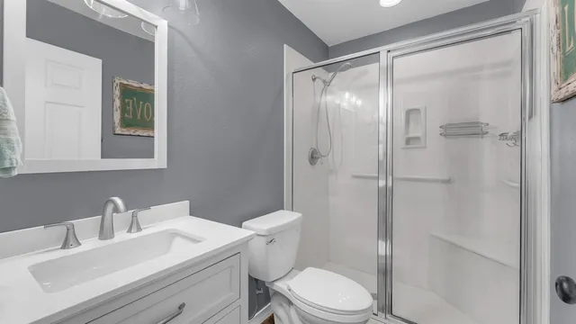 a bathroom with a sink a toilet and shower