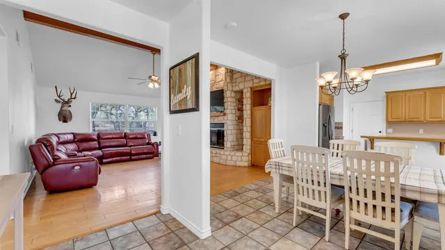 a living room with furniture a chandelier and a flat screen tv