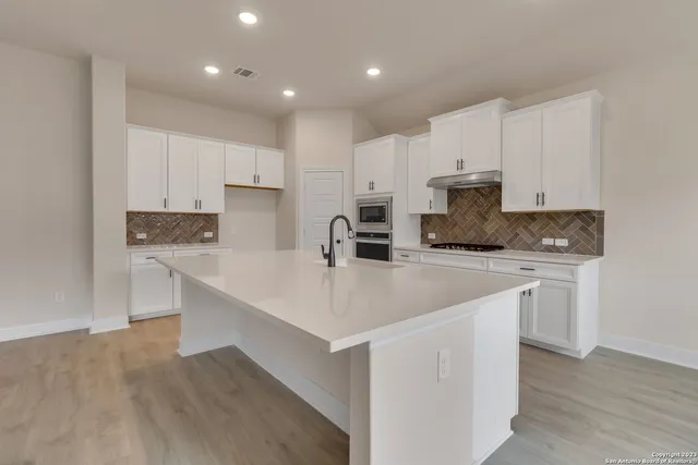 a kitchen with kitchen island white cabinets and white appliances