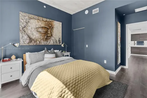 a bedroom with a bed and a painting on the wall