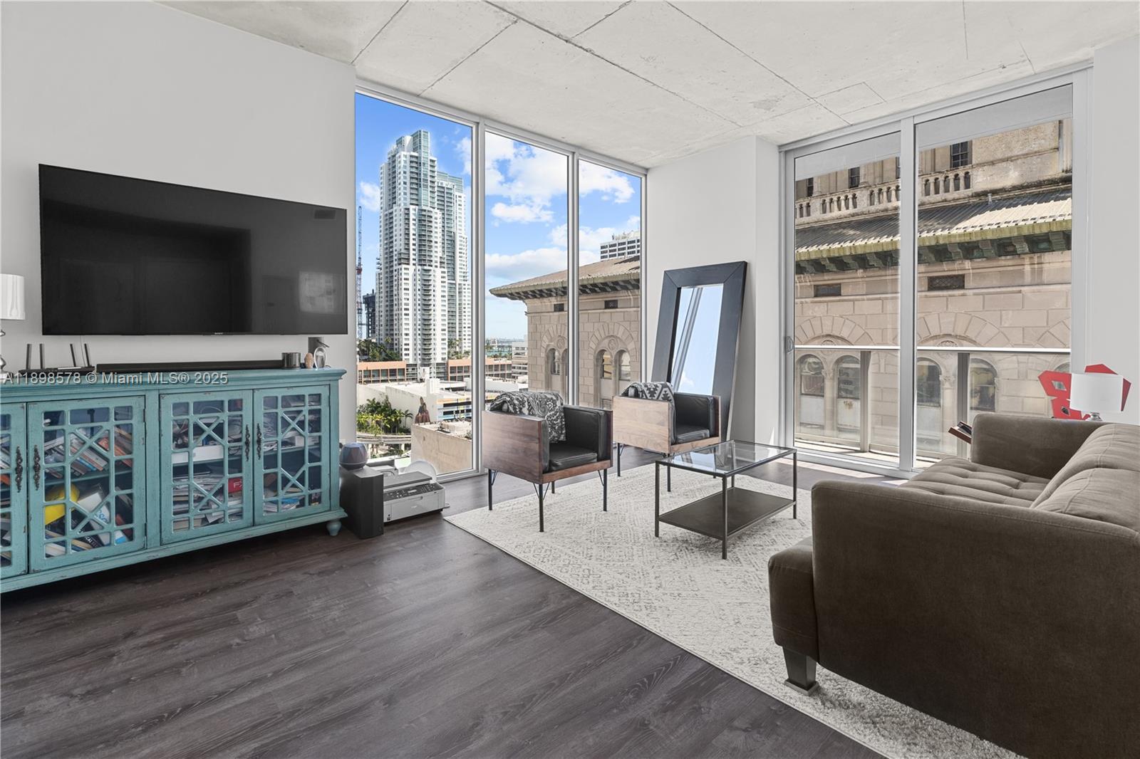 151 Southeast 1st Street, Unit 1402 Miami, FL 33131 - Photo 7 of 16 a living room with furniture and a flat screen tv