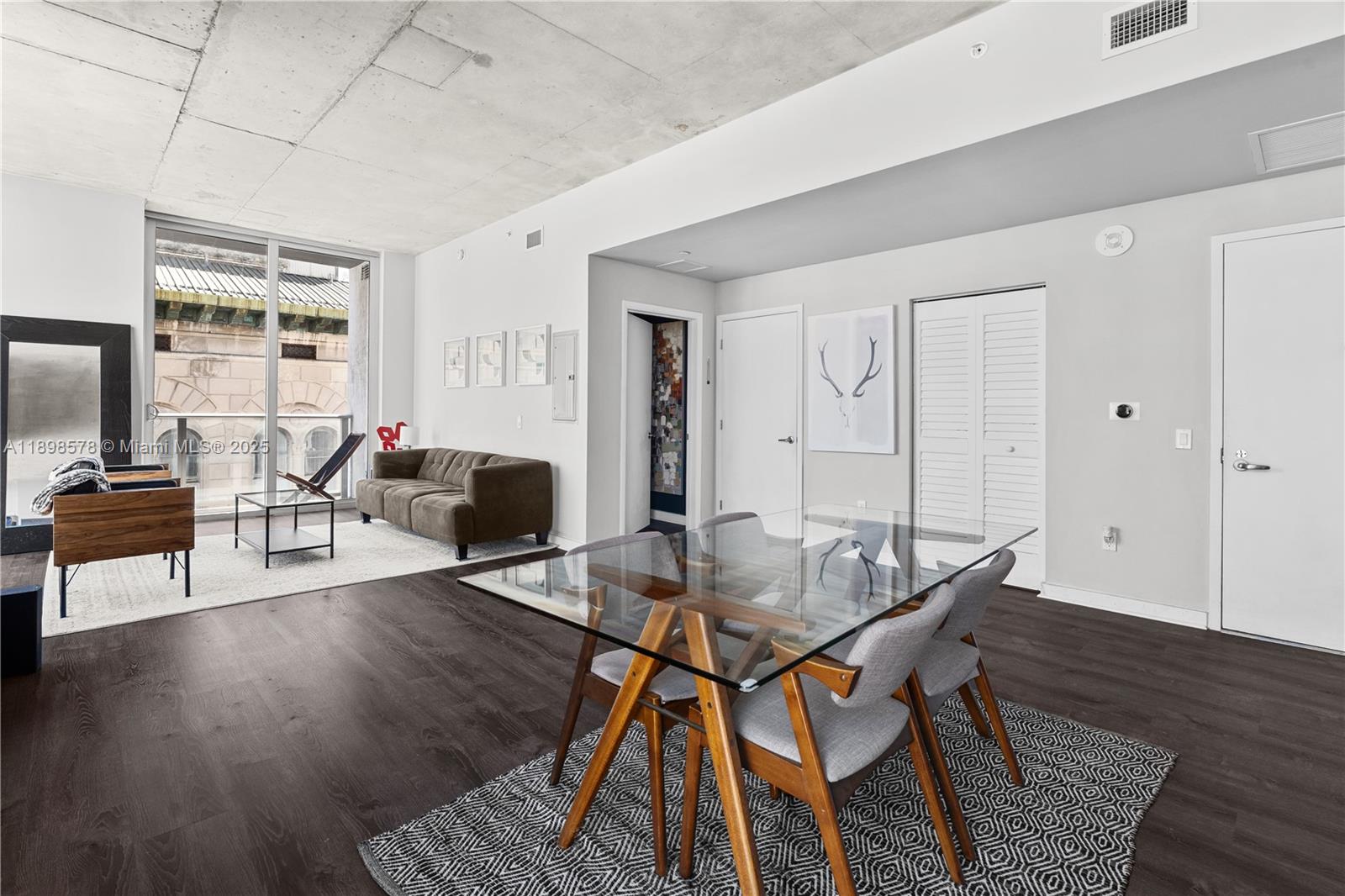 151 Southeast 1st Street, Unit 1402 Miami, FL 33131 - Photo 9 of 16 a view of a livingroom with furniture and a dining table chair