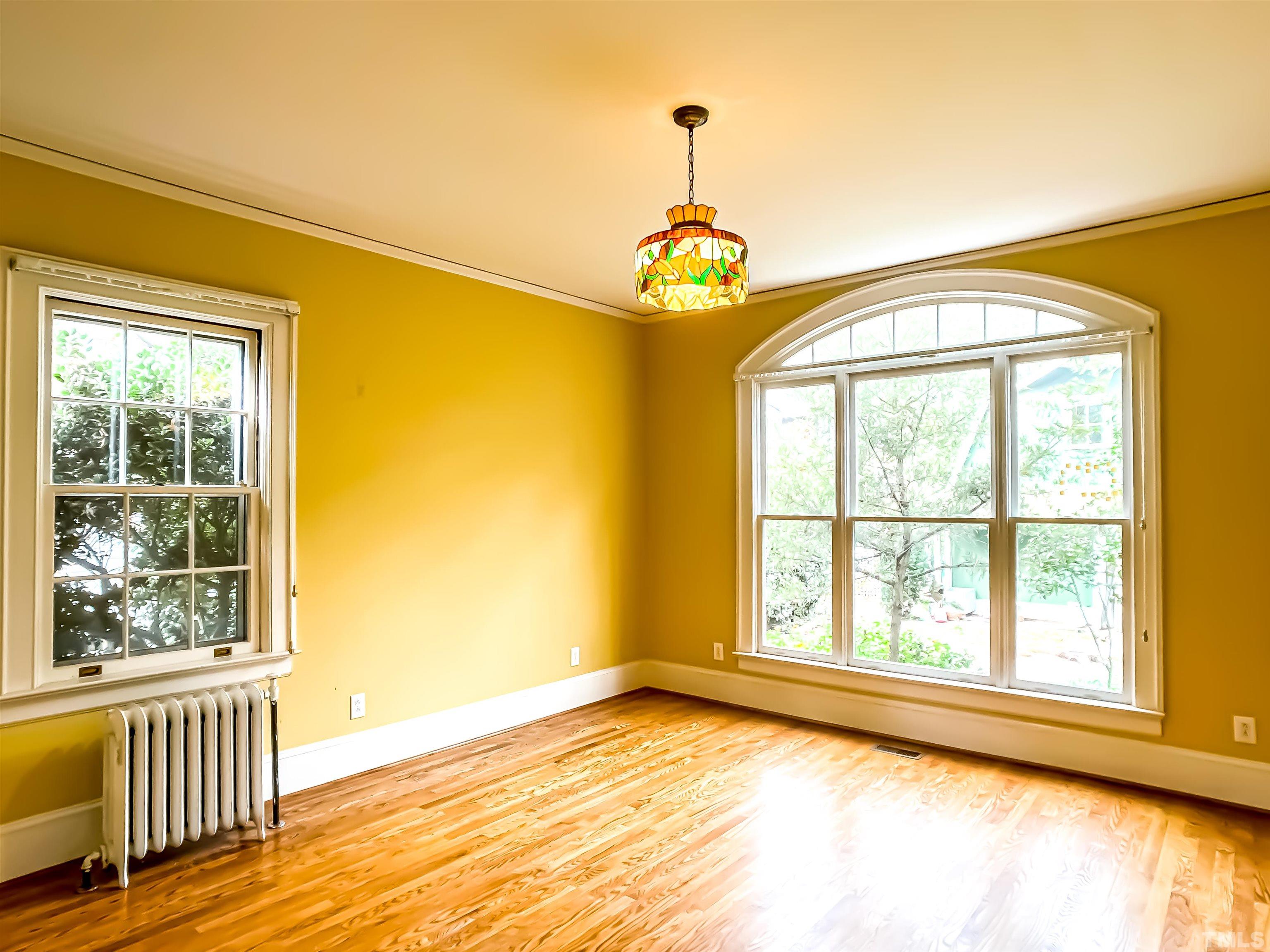205 Woodburn Road Raleigh, NC 27605 - Photo 14 of 42 a view of an empty room with wooden floor and a window