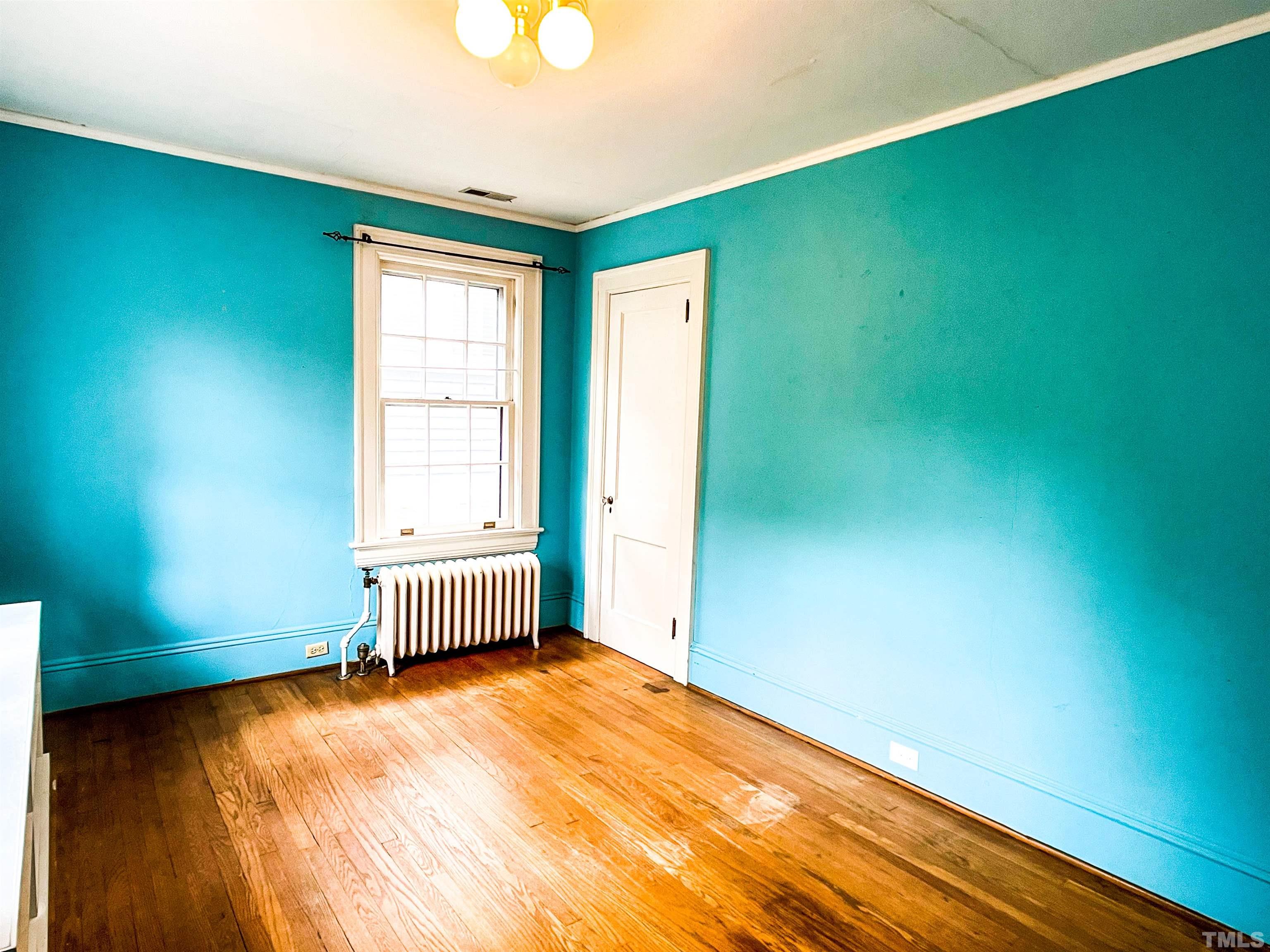 205 Woodburn Road Raleigh, NC 27605 - Photo 23 of 42 an empty room with wooden floor and windows