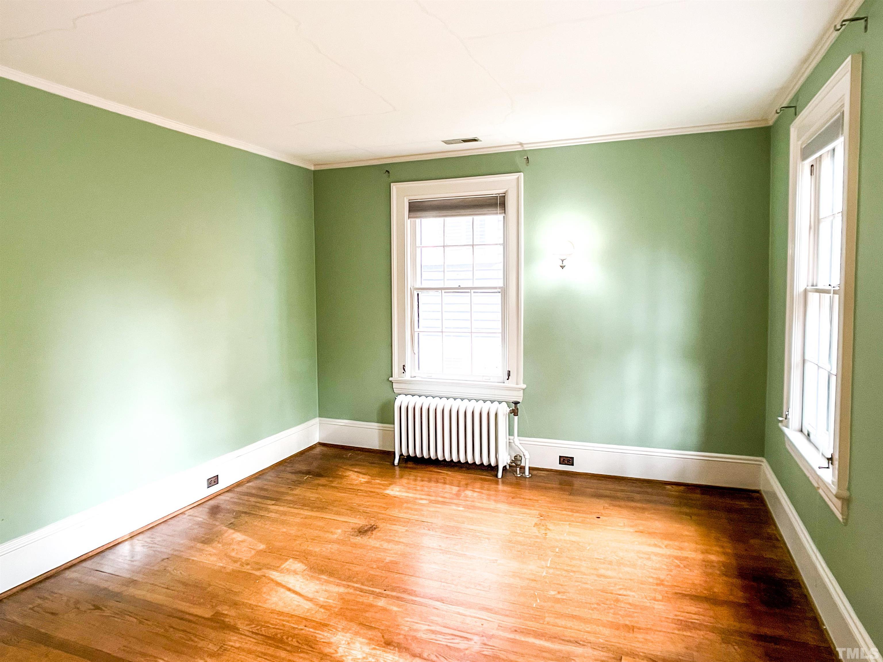 205 Woodburn Road Raleigh, NC 27605 - Photo 27 of 42 an empty room with wooden floor and windows