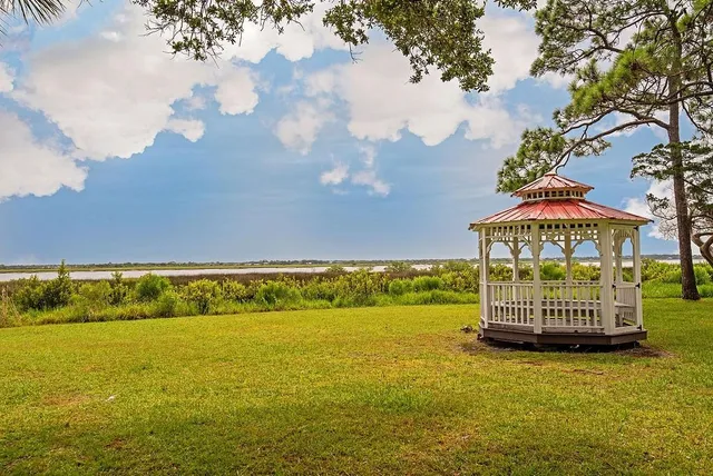 a view of a swimming pool with trees and sitting area