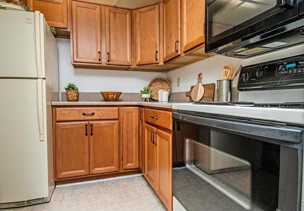 a kitchen with stainless steel appliances granite countertop a refrigerator and a stove top oven