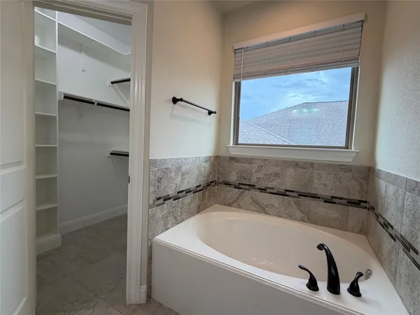 a bathroom with a granite countertop bathtub shower sink vanity and toilet