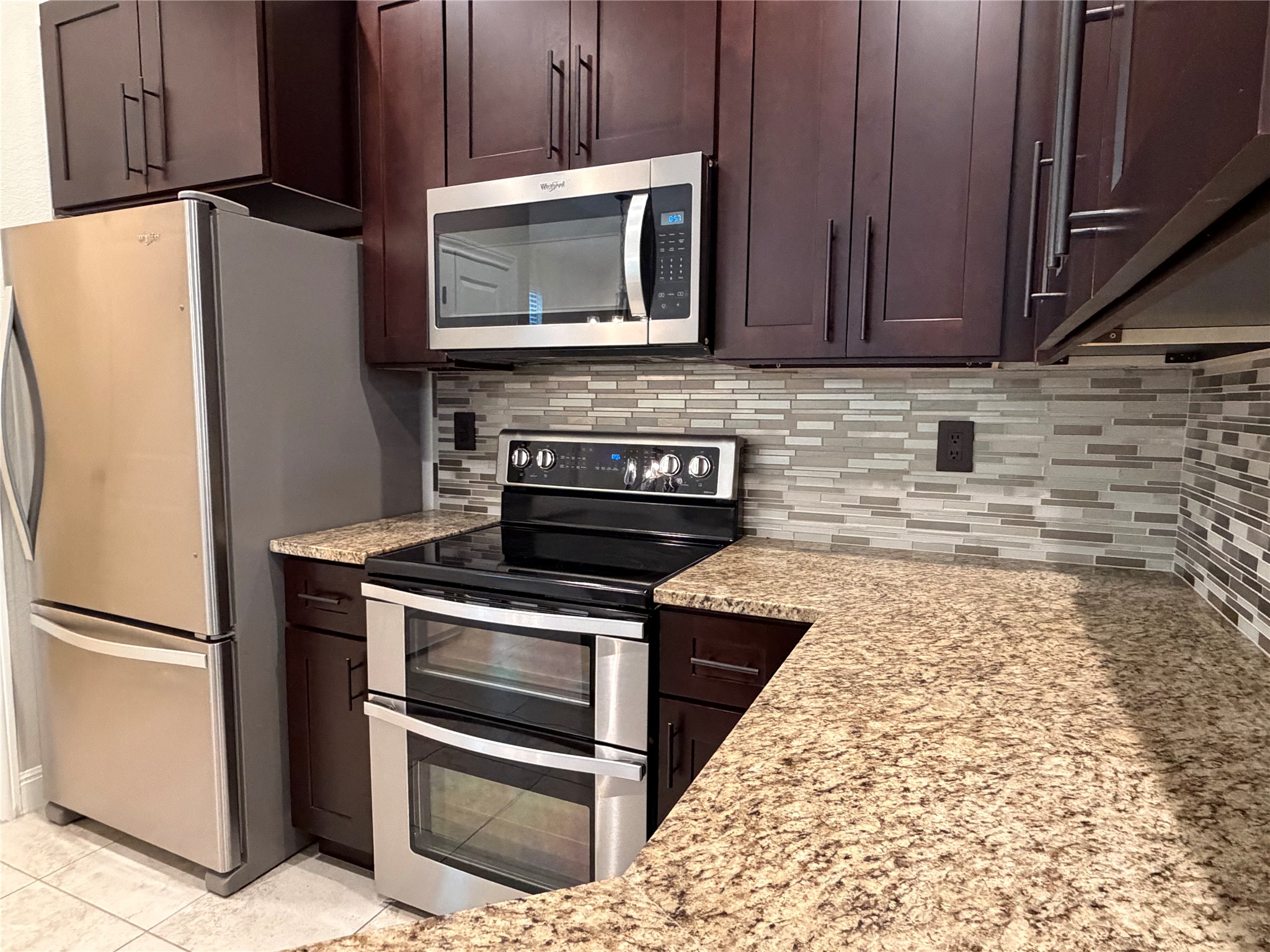 206 Fairway Circle Point Venture, TX 78645 - Photo 20 of 24 a kitchen with granite countertop a refrigerator stove and microwave