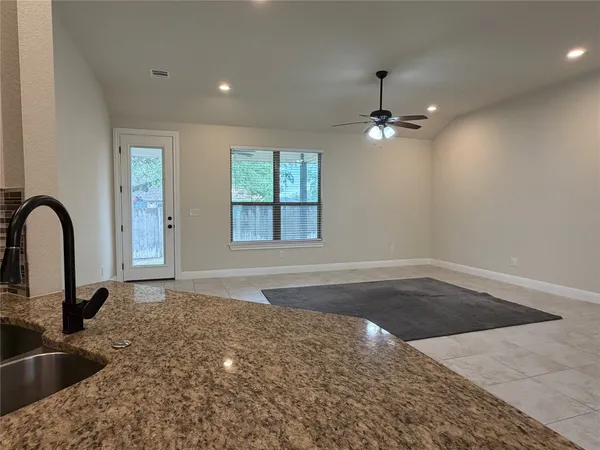 an empty room with windows and ceiling fan