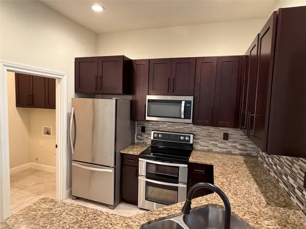 an empty room with closet and a chandelier fan