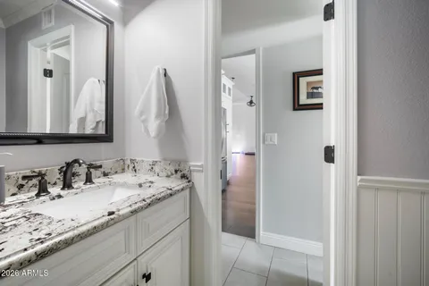 a large bedroom with a bed a flat screen tv and couches