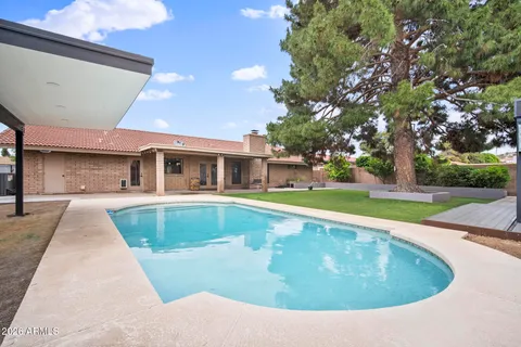 a view of a house with backyard and a tree