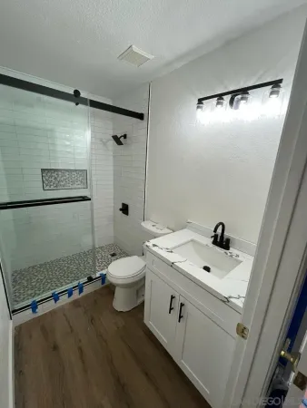 a bathroom with a sink a toilet and shower