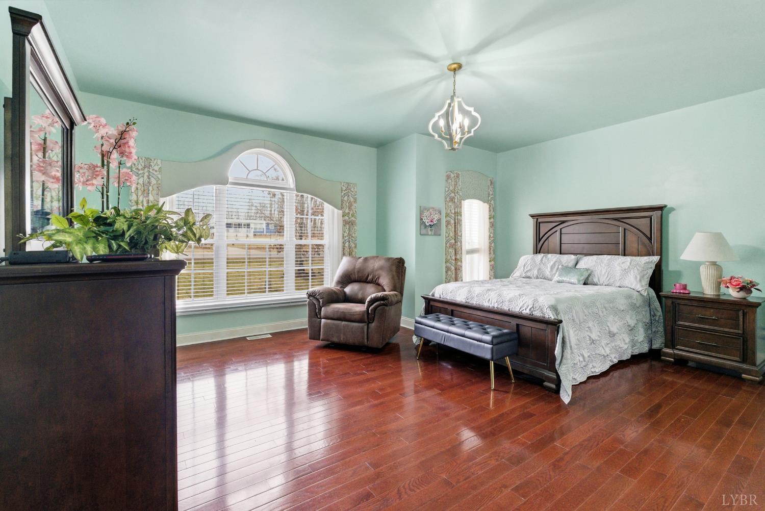 2067 Flint Hill Road Moneta, VA 24121 - Photo 18 of 70 a spacious bedroom with a bed and a wooden floor