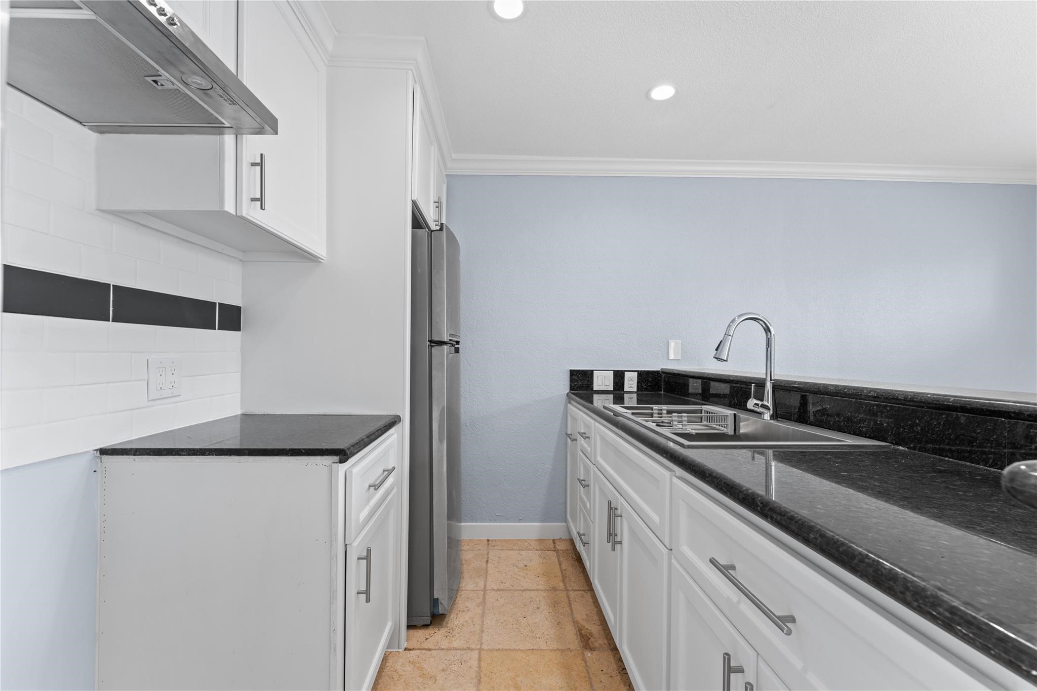 a kitchen with a sink and a refrigerator