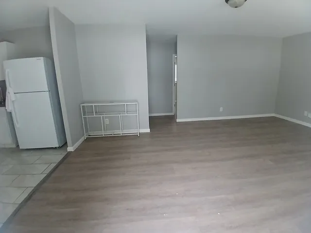 an empty room with wooden floor and door