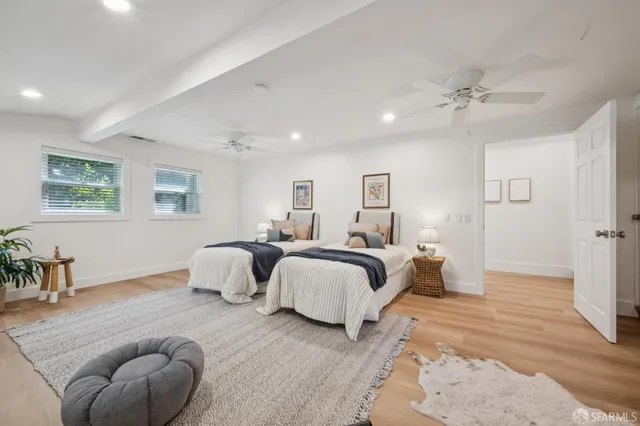 a spacious bedroom with a bed and ceiling fan