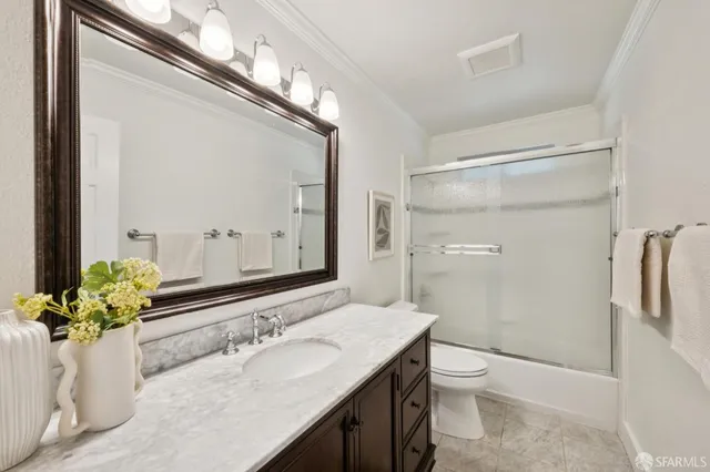 a bathroom with a granite countertop sink a toilet and a mirror