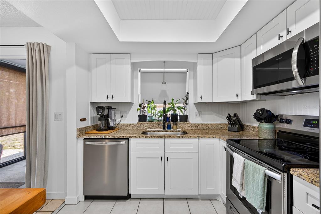 532 Center Road Venice, FL 34285 - Photo 41 of 68 a kitchen with white cabinets and appliances