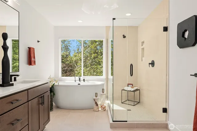 a bathroom with a tub sink mirror and shower