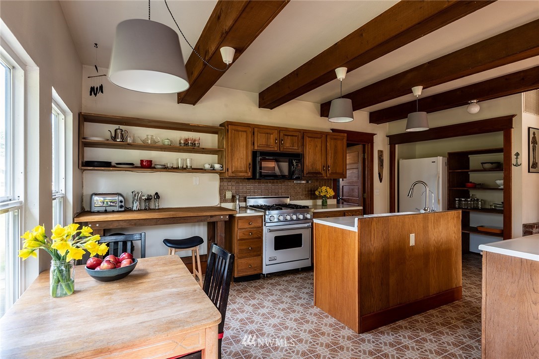 9048 Southwest Soper Road Vashon, WA 98070 - Photo 5 of 27 a kitchen with a stove a refrigerator and a dining table