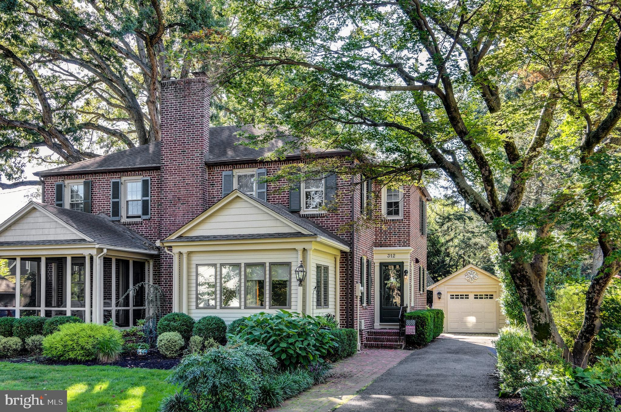 312 Woodland Avenue Haddonfield, NJ 08033 - Photo 1 of 44 a front view of a house with a garden