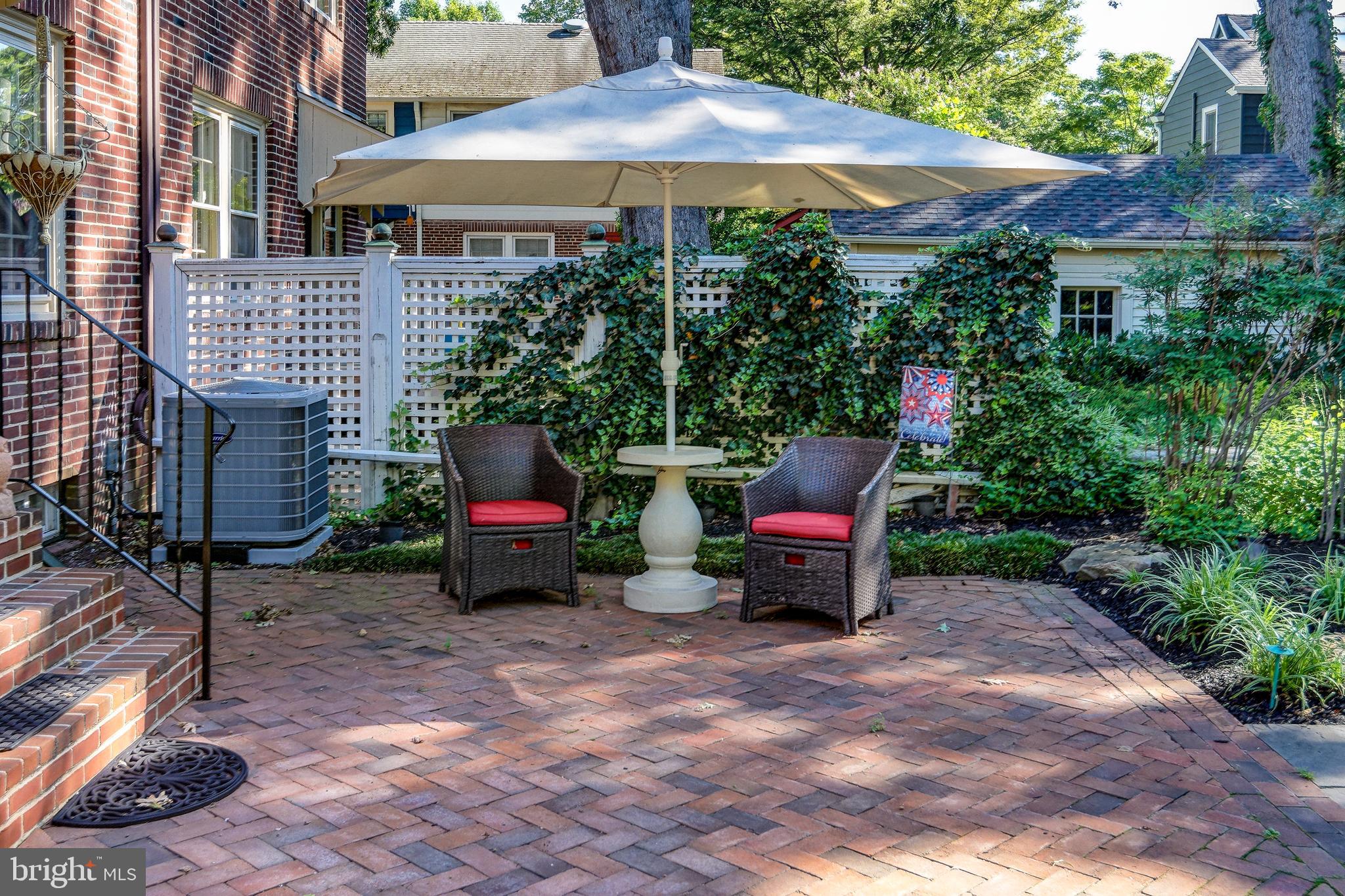 312 Woodland Avenue Haddonfield, NJ 08033 - Photo 11 of 44 a backyard of a house with table and chairs under an umbrella