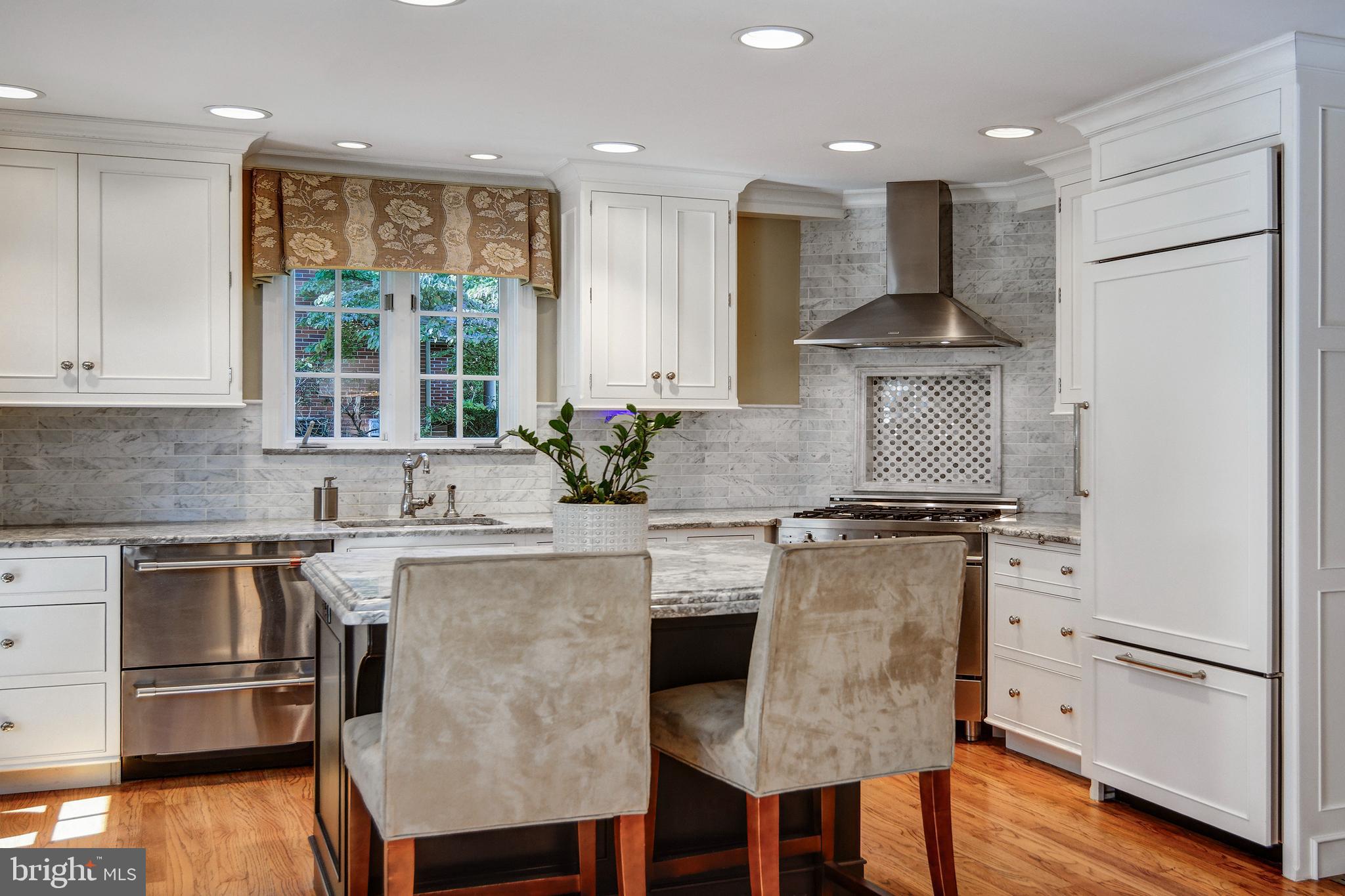 312 Woodland Avenue Haddonfield, NJ 08033 - Photo 28 of 44 a kitchen with stainless steel appliances granite countertop a stove top oven a refrigerator a sink and white cabinets with wooden floor