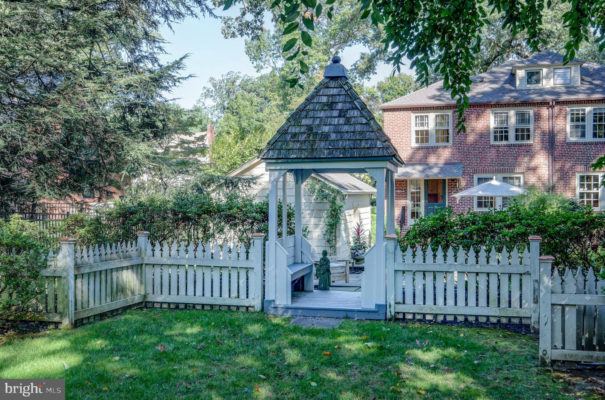 312 Woodland Avenue Haddonfield, NJ 08033 - Photo 9 of 44 a view of a pathway of a house with wooden fence next to a yard