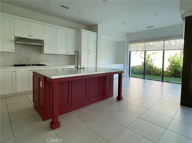 a kitchen with a sink a stove cabinets and glass door