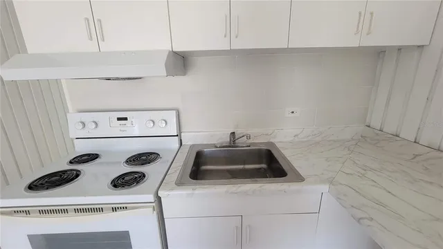 a kitchen with a stove and a white cabinet